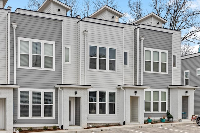 back of house featuring uncovered parking