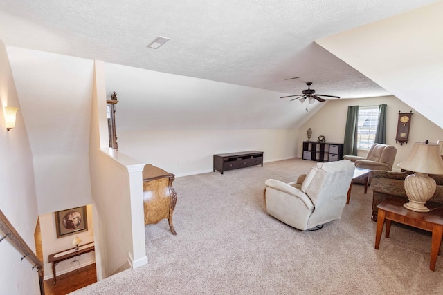 living room with visible vents, light colored carpet, lofted ceiling, ceiling fan, and a textured ceiling