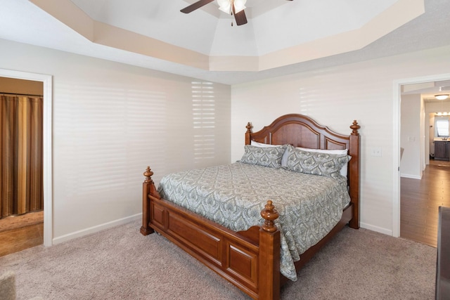 bedroom with carpet, baseboards, and a raised ceiling