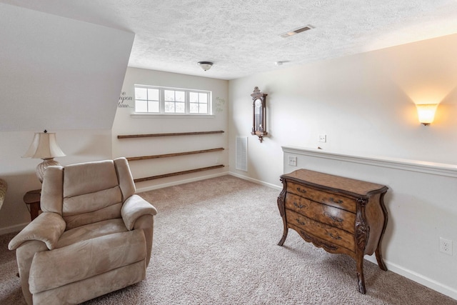 living area featuring baseboards, carpet, visible vents, and a textured ceiling