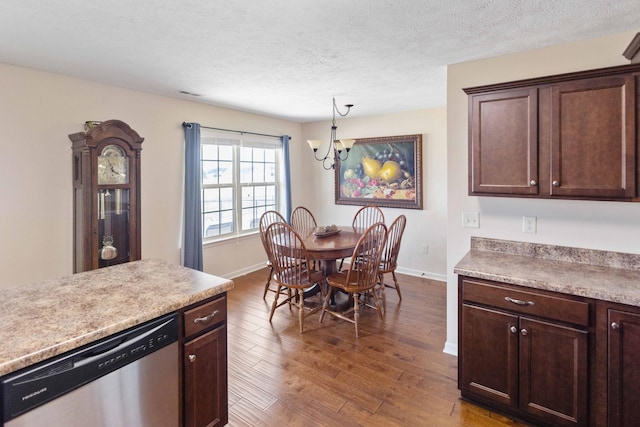 dining room with dark wood-type flooring, a notable chandelier, a textured ceiling, and baseboards