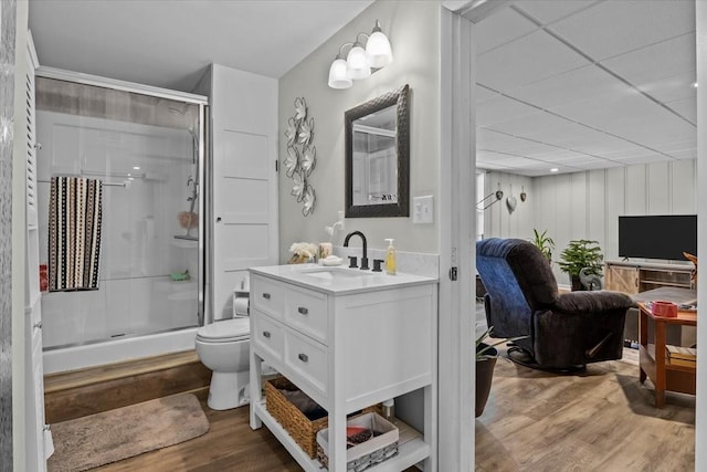 full bath with vanity, a stall shower, wood finished floors, and toilet