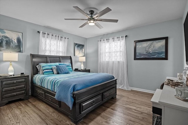 bedroom featuring wood finished floors, a ceiling fan, and baseboards