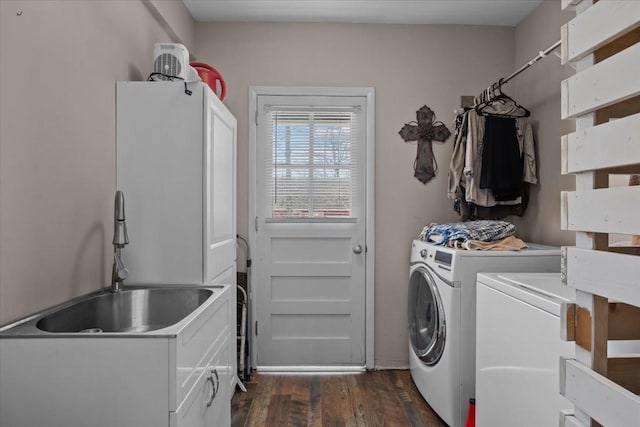 clothes washing area featuring cabinet space, washing machine and dryer, dark wood finished floors, and a sink