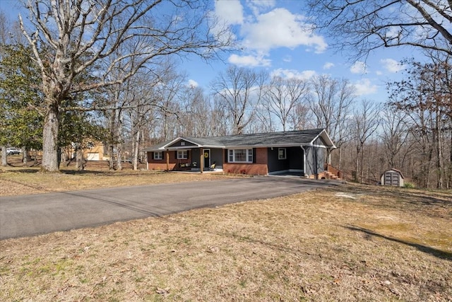 ranch-style home with a front yard, aphalt driveway, and brick siding