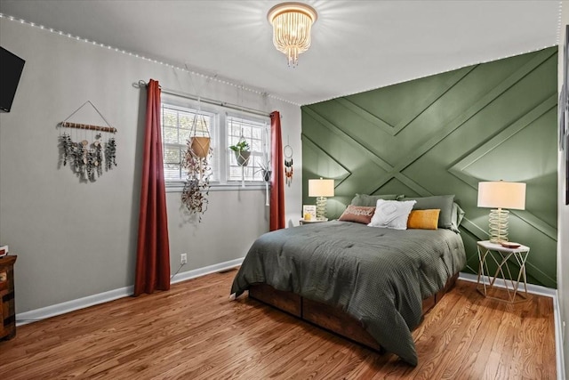 bedroom with baseboards and wood finished floors