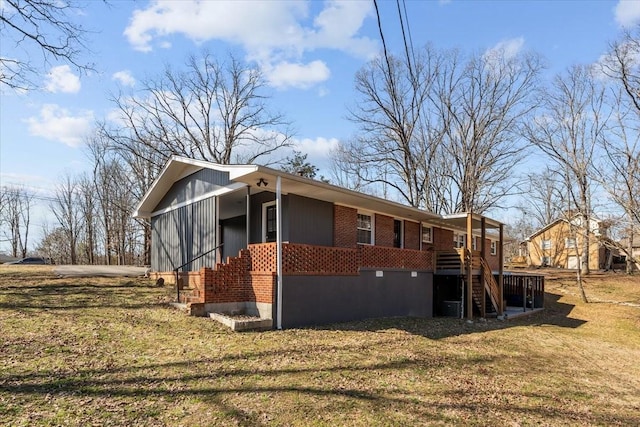 view of side of property with stairs, a yard, and brick siding