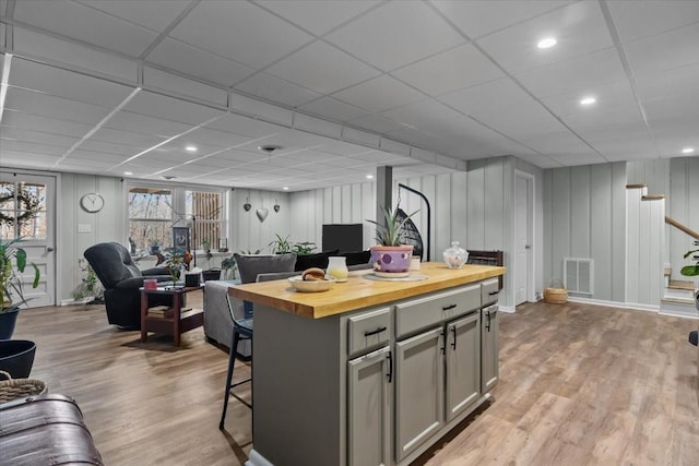 kitchen featuring butcher block countertops, gray cabinets, visible vents, and wood finished floors