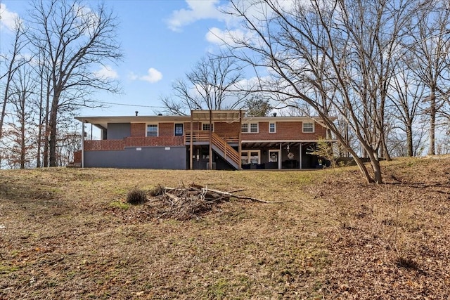 rear view of house with stairs and brick siding