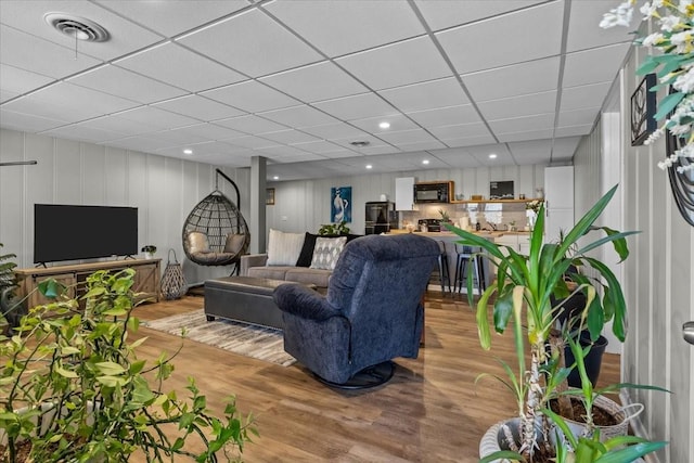 living room featuring recessed lighting, visible vents, a drop ceiling, and light wood finished floors