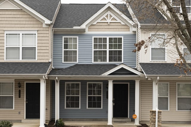 multi unit property featuring a porch and a shingled roof