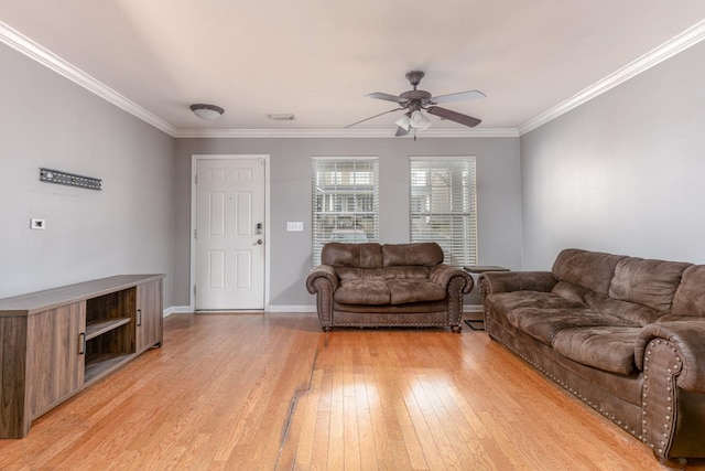 living room with ornamental molding, light wood-type flooring, visible vents, and a ceiling fan