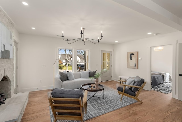 living room with recessed lighting, a notable chandelier, baseboards, and light wood-style floors