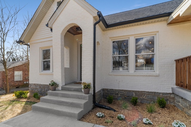doorway to property featuring brick siding