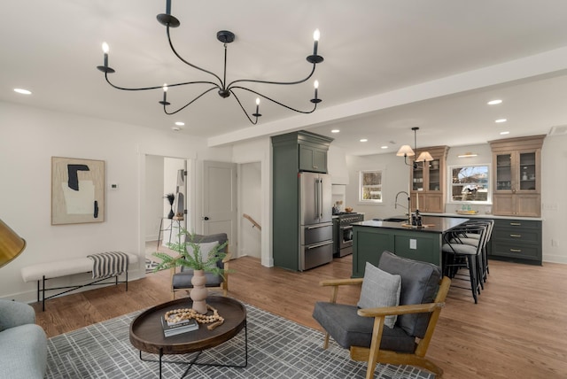 living room with light wood-style flooring, recessed lighting, baseboards, and a chandelier