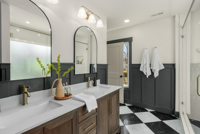 bathroom with a sink, double vanity, a shower stall, and tile patterned floors