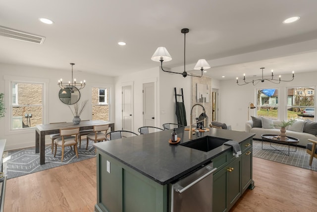 kitchen with visible vents, an inviting chandelier, a sink, stainless steel dishwasher, and dark countertops