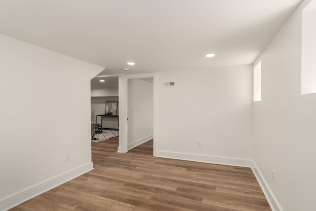 empty room featuring recessed lighting, baseboards, and wood finished floors