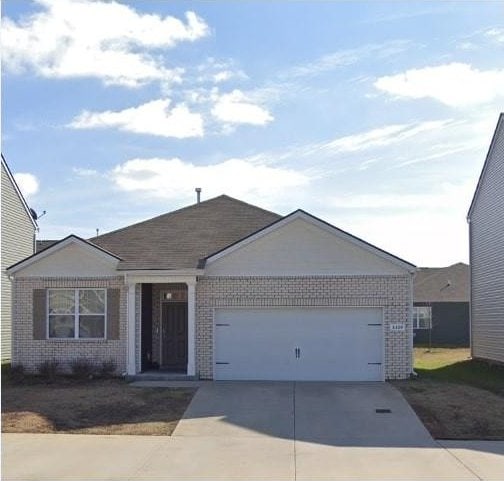 single story home featuring concrete driveway, brick siding, and an attached garage