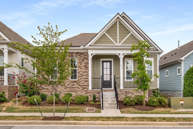 view of front of house with a porch and brick siding