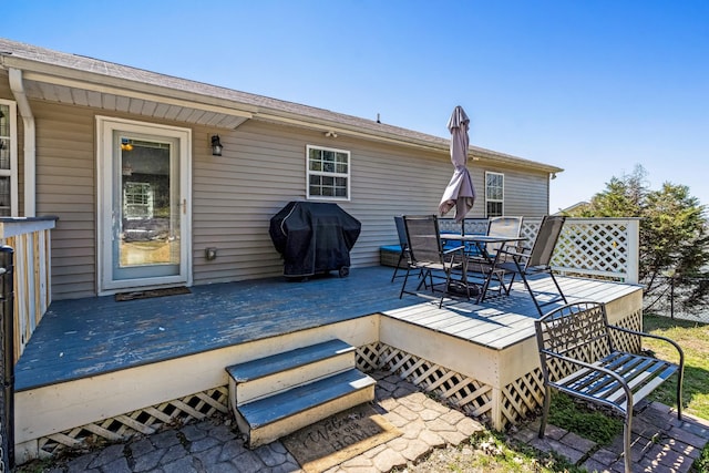 wooden terrace featuring grilling area and outdoor dining space