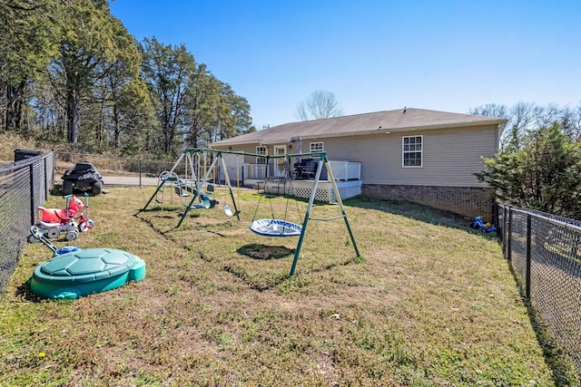 back of house with a yard, a playground, and a fenced backyard