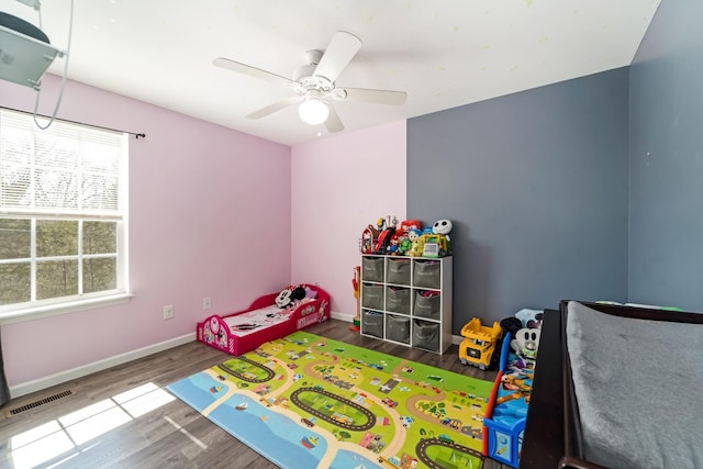 bedroom with visible vents, baseboards, wood finished floors, and a ceiling fan