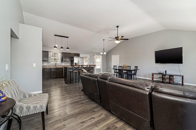 living room with a ceiling fan, lofted ceiling, dark wood-style floors, and baseboards