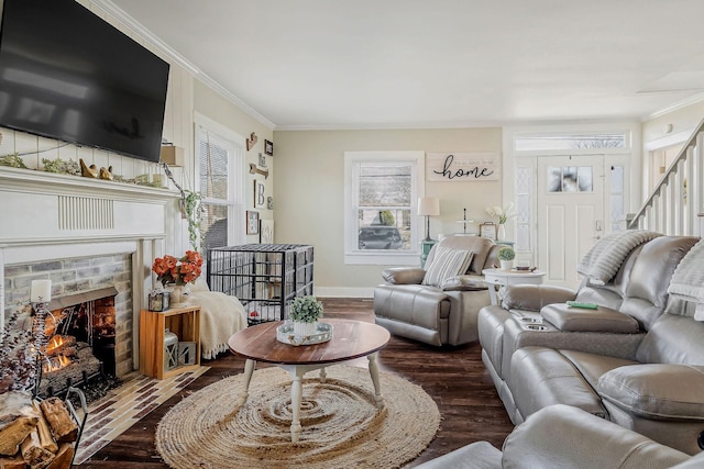 living area with baseboards, dark wood-style floors, a fireplace with flush hearth, stairs, and crown molding