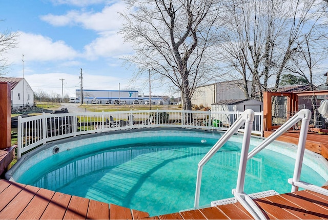 view of pool featuring a shed, fence, and an outbuilding