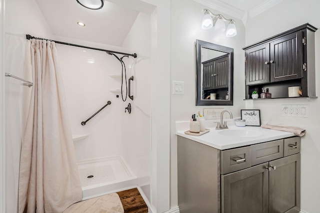 bathroom featuring a stall shower, wood finished floors, crown molding, and vanity