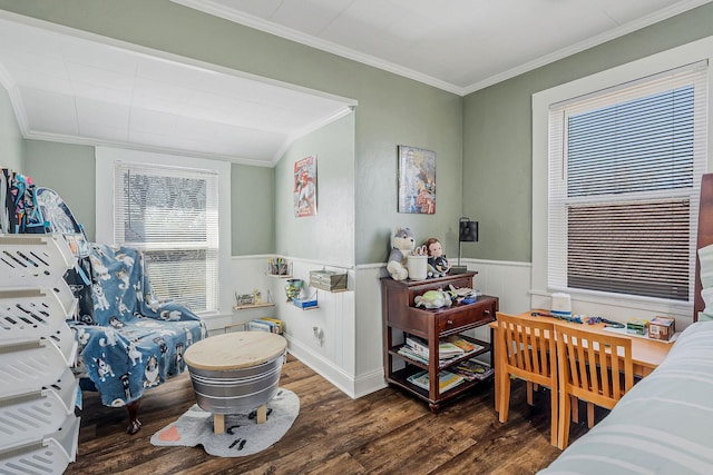 bedroom featuring ornamental molding, wainscoting, and wood finished floors