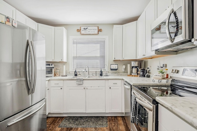 kitchen featuring stainless steel appliances, a sink, and white cabinets