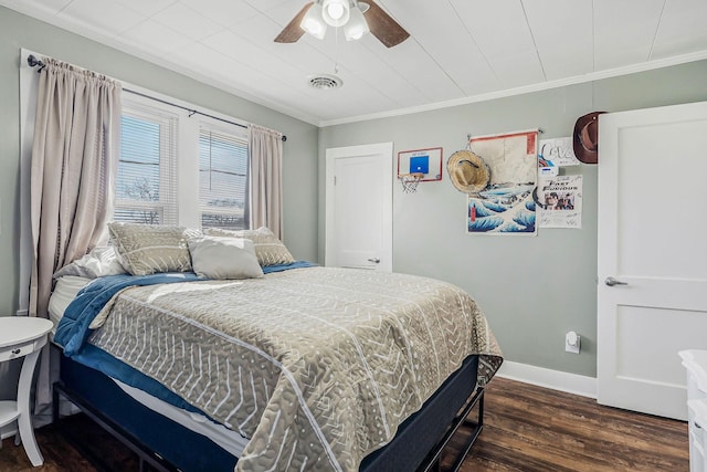 bedroom with ceiling fan, wood finished floors, visible vents, baseboards, and crown molding