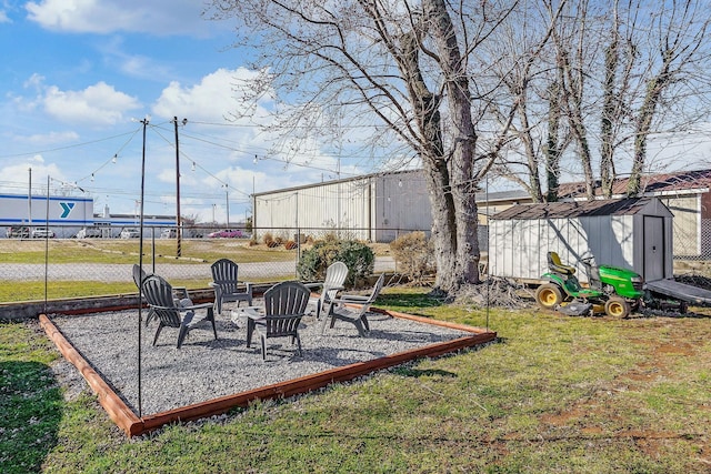 view of yard with a fire pit, an outdoor structure, fence, a shed, and a patio area