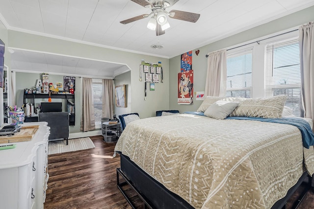 bedroom featuring arched walkways, a ceiling fan, visible vents, dark wood finished floors, and crown molding