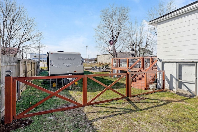 view of gate with a yard and fence