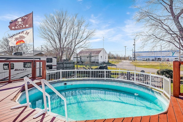 view of swimming pool with fence and a wooden deck