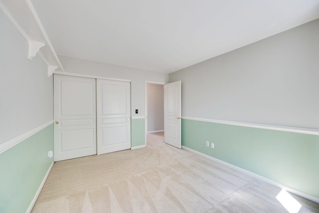 unfurnished bedroom featuring a closet, carpet, and baseboards