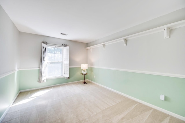 empty room with carpet floors, baseboards, and visible vents