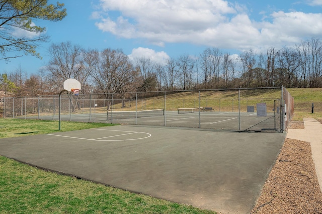 view of sport court featuring a tennis court, community basketball court, a lawn, and fence