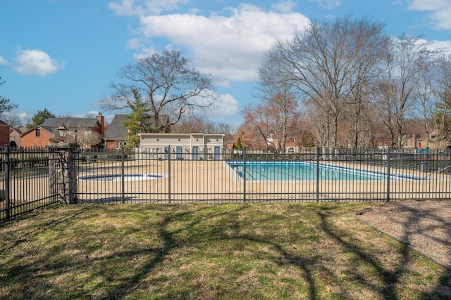 pool with a patio area, fence, and a yard