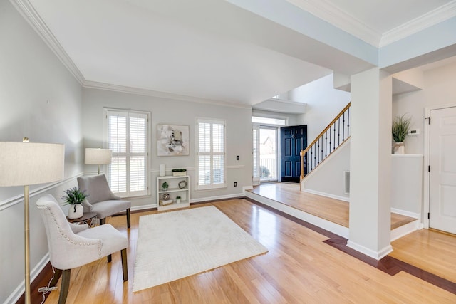 interior space featuring a wealth of natural light, stairs, ornamental molding, and wood finished floors