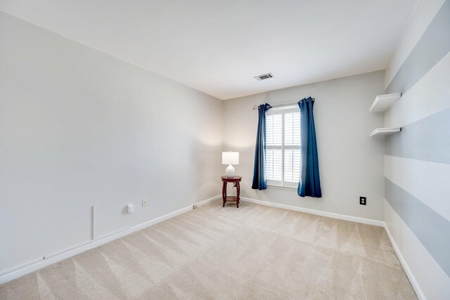 carpeted empty room featuring visible vents and baseboards