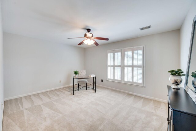 office area featuring light carpet, baseboards, visible vents, and a ceiling fan