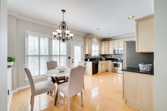 dining area with a chandelier, light wood-style flooring, and crown molding