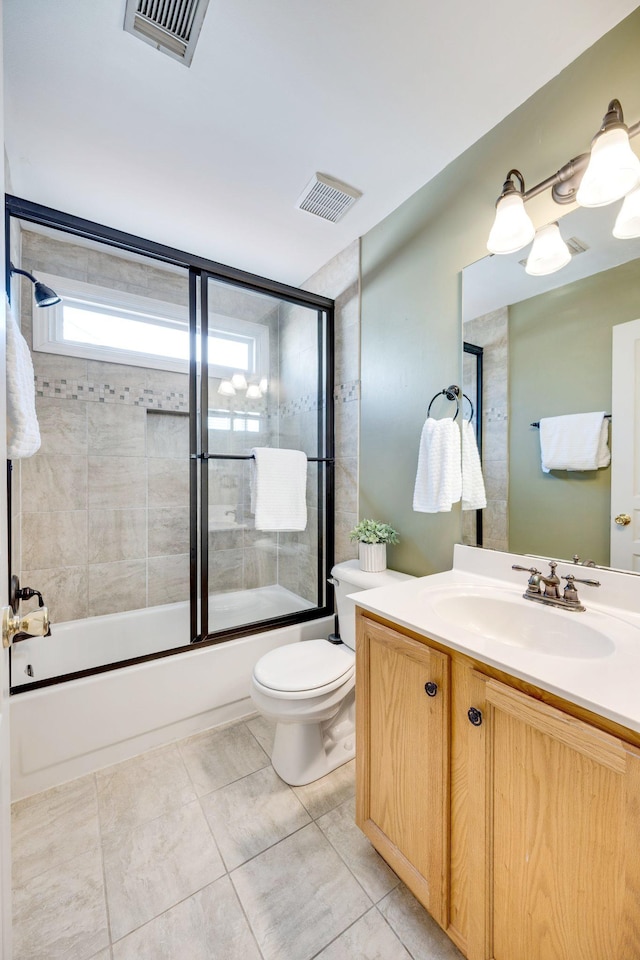 full bath featuring toilet, combined bath / shower with glass door, vanity, and visible vents