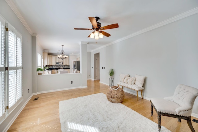 living area with light wood finished floors, baseboards, and crown molding