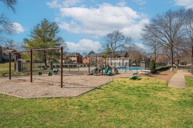 communal playground featuring a yard and fence