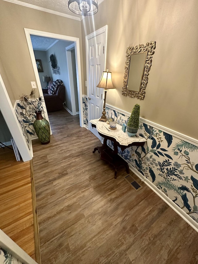 dining area with a chandelier, ornamental molding, wood finished floors, and visible vents